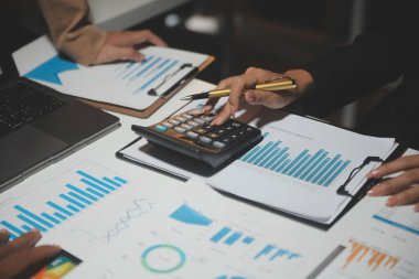 Finansal analistler, şirketlerin başarılı takım çalışmalarının sonuçlarını gösteren bir toplantıda bir dijital tablet planlama yatırım projesinin ticari mali raporlarını analiz ediyorlar..