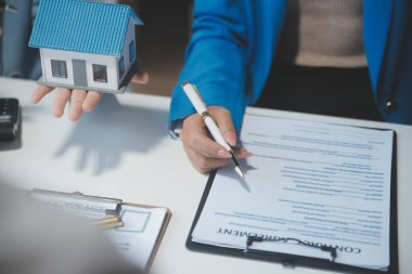 Emlakçı ve müşteri ev, sigorta ya da emlak satın almak için sözleşme imzalarlar. Ev kiralarlar, sigorta yaptırırlar, emlak veya emlak kredisi alırlar..
