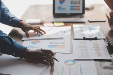 Modern dizüstü bilgisayarla gelir tabloları ve grafiklerini analiz eden iş ekibini kapatın. İş analizi ve strateji kavramı.