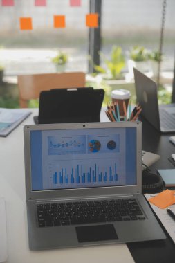 İş ekibi toplantısı yeni bir başlangıç projesi üzerinde çalışıyor, verileri tartışıyor ve analiz ediyor çizelgeler ve grafikler. Dijital tablet, hesap makinesi, dizüstü bilgisayar kullanımı, iş finans ve muhasebe kavramı.