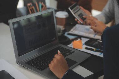 İş ekibi toplantısı yeni bir başlangıç projesi üzerinde çalışıyor, verileri tartışıyor ve analiz ediyor çizelgeler ve grafikler. Dijital tablet, hesap makinesi, dizüstü bilgisayar kullanımı, iş finans ve muhasebe kavramı.