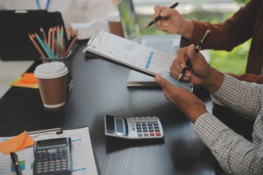 İş ekibi toplantısı yeni bir başlangıç projesi üzerinde çalışıyor, verileri tartışıyor ve analiz ediyor çizelgeler ve grafikler. Dijital tablet, hesap makinesi, dizüstü bilgisayar kullanımı, iş finans ve muhasebe kavramı.