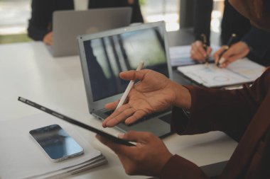 İş ekibi toplantısı yeni bir başlangıç projesi üzerinde çalışıyor, verileri tartışıyor ve analiz ediyor çizelgeler ve grafikler. Dijital tablet, hesap makinesi, dizüstü bilgisayar kullanımı, iş finans ve muhasebe kavramı.