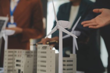 Tablete yakın çekim, Mühendisler tableti elleriyle işaret ediyorlar. Rüzgar ve güneş enerjisiyle yenilenebilir enerji kullanımını ortaklaşa tasarlamak için. Yenilenebilir enerji kullanma kavramı.