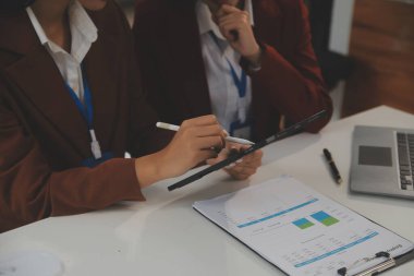 İş adamlarıyla takım çalışması toplantı odasındaki masanın üzerinde maliyet analizi grafiği. İş dünyası ekibi toplantıları ve brifing stratejilerini tartıştı. Pazarlık, Analiz, Tartışma