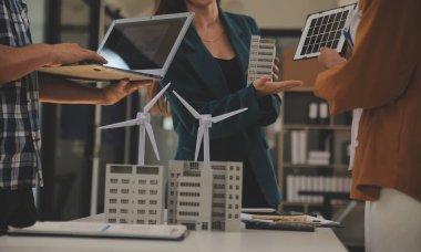 Elektrik mühendisi ve iş adamı binanın çatısındaki yeni güneş pili panelini tartışıyorlar. Alternatif enerji kavramı.