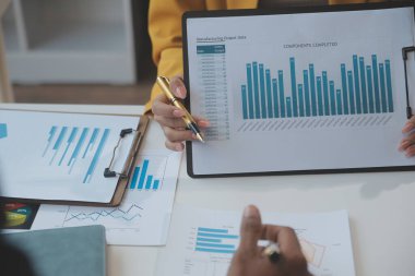 Finansal analistler, şirketlerin başarılı takım çalışmalarının sonuçlarını gösteren bir toplantıda bir dijital tablet planlama yatırım projesinin ticari mali raporlarını analiz ediyorlar..