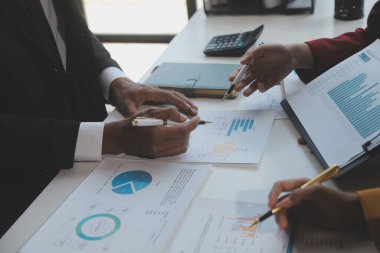 Finansal analistler, şirketlerin başarılı takım çalışmalarının sonuçlarını gösteren bir toplantıda bir dijital tablet planlama yatırım projesinin ticari mali raporlarını analiz ediyorlar..