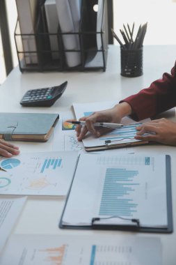 Finansal analistler, şirketlerin başarılı takım çalışmalarının sonuçlarını gösteren bir toplantıda bir dijital tablet planlama yatırım projesinin ticari mali raporlarını analiz ediyorlar..