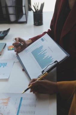 Finansal analistler, şirketlerin başarılı takım çalışmalarının sonuçlarını gösteren bir toplantıda bir dijital tablet planlama yatırım projesinin ticari mali raporlarını analiz ediyorlar..