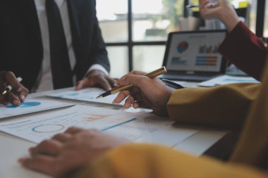 Finansal analistler, şirketlerin başarılı takım çalışmalarının sonuçlarını gösteren bir toplantıda bir dijital tablet planlama yatırım projesinin ticari mali raporlarını analiz ediyorlar..