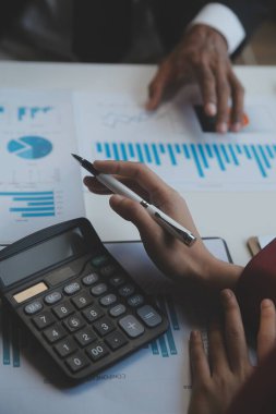 Finansal analistler, şirketlerin başarılı takım çalışmalarının sonuçlarını gösteren bir toplantıda bir dijital tablet planlama yatırım projesinin ticari mali raporlarını analiz ediyorlar..