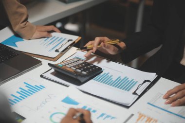 Finansal analistler, şirketlerin başarılı takım çalışmalarının sonuçlarını gösteren bir toplantıda bir dijital tablet planlama yatırım projesinin ticari mali raporlarını analiz ediyorlar..