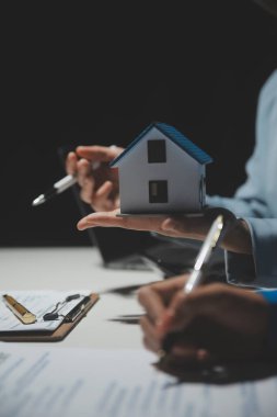 Emlakçı ve müşteri ev, sigorta ya da emlak satın almak için sözleşme imzalarlar. Ev kiralarlar, sigorta yaptırırlar, emlak veya emlak kredisi alırlar..