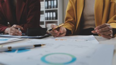 Finansal analistler, şirketlerin başarılı takım çalışmalarının sonuçlarını gösteren bir toplantıda bir dijital tablet planlama yatırım projesinin ticari mali raporlarını analiz ediyorlar..