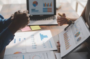 Modern dizüstü bilgisayarla gelir tabloları ve grafiklerini analiz eden iş ekibini kapatın. İş analizi ve strateji kavramı.