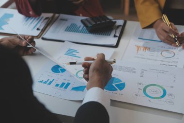 Finansal analistler, şirketlerin başarılı takım çalışmalarının sonuçlarını gösteren bir toplantıda bir dijital tablet planlama yatırım projesinin ticari mali raporlarını analiz ediyorlar..