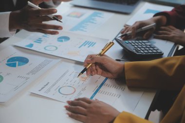 Finansal analistler, şirketlerin başarılı takım çalışmalarının sonuçlarını gösteren bir toplantıda bir dijital tablet planlama yatırım projesinin ticari mali raporlarını analiz ediyorlar..