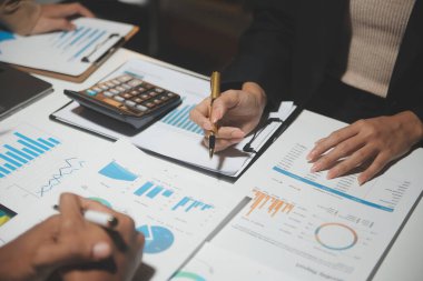 Finansal analistler, şirketlerin başarılı takım çalışmalarının sonuçlarını gösteren bir toplantıda bir dijital tablet planlama yatırım projesinin ticari mali raporlarını analiz ediyorlar..