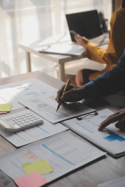 Modern dizüstü bilgisayarla gelir tabloları ve grafiklerini analiz eden iş ekibini kapatın. İş analizi ve strateji kavramı.