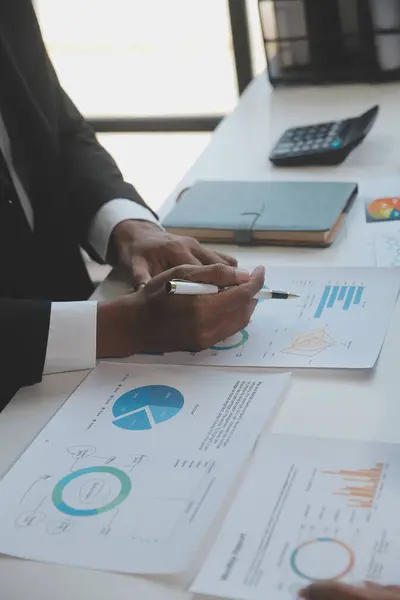 Finansal analistler, şirketlerin başarılı takım çalışmalarının sonuçlarını gösteren bir toplantıda bir dijital tablet planlama yatırım projesinin ticari mali raporlarını analiz ediyorlar..