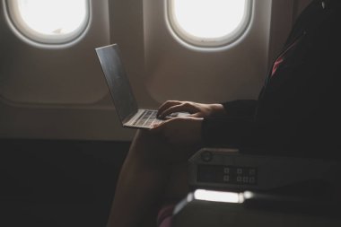 Sarışın kadın turist gelen bildirim netbook ile uçak koltuğunda oturan Smartphone cep telefonu ile kontrol. Genç işkadını paylaşmak medya telefonu dizüstü bilgisayar üzerinde uçak uçuş sırasında