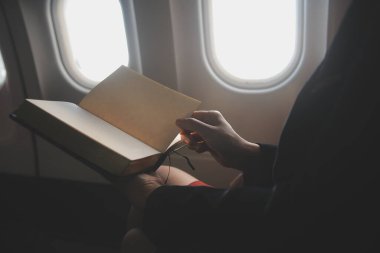 Sarışın kadın turist gelen bildirim netbook ile uçak koltuğunda oturan Smartphone cep telefonu ile kontrol. Genç işkadını paylaşmak medya telefonu dizüstü bilgisayar üzerinde uçak uçuş sırasında
