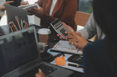 İş ekibi toplantısı yeni bir başlangıç projesi üzerinde çalışıyor, verileri tartışıyor ve analiz ediyor çizelgeler ve grafikler. Dijital tablet, hesap makinesi, dizüstü bilgisayar kullanımı, iş finans ve muhasebe kavramı.