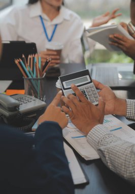 İş ekibi toplantısı yeni bir başlangıç projesi üzerinde çalışıyor, verileri tartışıyor ve analiz ediyor çizelgeler ve grafikler. Dijital tablet, hesap makinesi, dizüstü bilgisayar kullanımı, iş finans ve muhasebe kavramı.