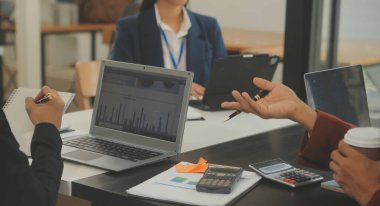 İş ekibi toplantısı yeni bir başlangıç projesi üzerinde çalışıyor, verileri tartışıyor ve analiz ediyor çizelgeler ve grafikler. Dijital tablet, hesap makinesi, dizüstü bilgisayar kullanımı, iş finans ve muhasebe kavramı.