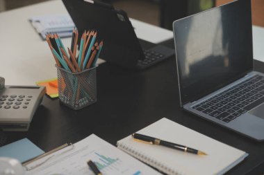 İş ekibi toplantısı yeni bir başlangıç projesi üzerinde çalışıyor, verileri tartışıyor ve analiz ediyor çizelgeler ve grafikler. Dijital tablet, hesap makinesi, dizüstü bilgisayar kullanımı, iş finans ve muhasebe kavramı.