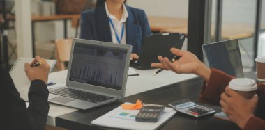 İş ekibi toplantısı yeni bir başlangıç projesi üzerinde çalışıyor, verileri tartışıyor ve analiz ediyor çizelgeler ve grafikler. Dijital tablet, hesap makinesi, dizüstü bilgisayar kullanımı, iş finans ve muhasebe kavramı.