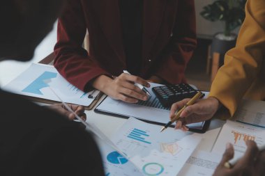 Finansal analistler, şirketlerin başarılı takım çalışmalarının sonuçlarını gösteren bir toplantıda bir dijital tablet planlama yatırım projesinin ticari mali raporlarını analiz ediyorlar..