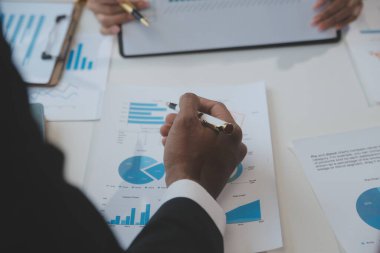Finansal analistler, şirketlerin başarılı takım çalışmalarının sonuçlarını gösteren bir toplantıda bir dijital tablet planlama yatırım projesinin ticari mali raporlarını analiz ediyorlar..