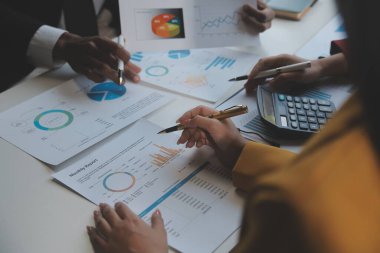 Finansal analistler, şirketlerin başarılı takım çalışmalarının sonuçlarını gösteren bir toplantıda bir dijital tablet planlama yatırım projesinin ticari mali raporlarını analiz ediyorlar..