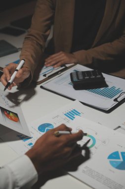 Finansal analistler, şirketlerin başarılı takım çalışmalarının sonuçlarını gösteren bir toplantıda bir dijital tablet planlama yatırım projesinin ticari mali raporlarını analiz ediyorlar..