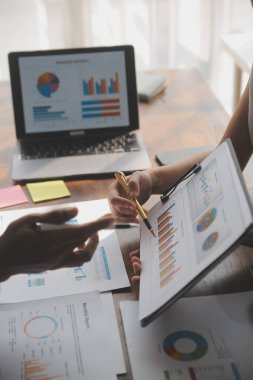 Modern dizüstü bilgisayarla gelir tabloları ve grafiklerini analiz eden iş ekibini kapatın. İş analizi ve strateji kavramı.