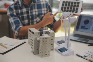 Elektrik mühendisi ve iş adamı binanın çatısındaki yeni güneş pili panelini tartışıyorlar. Alternatif enerji kavramı.