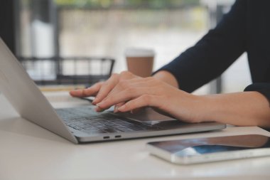 Asyalı iş kadını dizüstü bilgisayar kullanıyor ve ofiste hesap makinesi ile çalışıyor, mali raporu, iş planı yatırımını, mali analiz konseptini analiz etmeyi planlıyor..