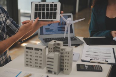 Elektrik mühendisi ve iş adamı binanın çatısındaki yeni güneş pili panelini tartışıyorlar. Alternatif enerji kavramı.
