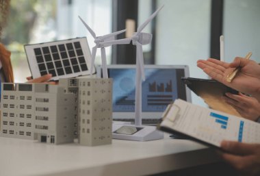 Elektrik mühendisi ve iş adamı binanın çatısındaki yeni güneş pili panelini tartışıyorlar. Alternatif enerji kavramı.