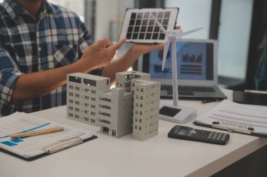 Elektrik mühendisi ve iş adamı binanın çatısındaki yeni güneş pili panelini tartışıyorlar. Alternatif enerji kavramı.