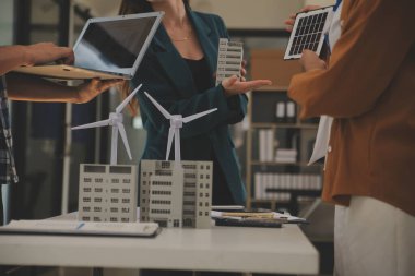 Elektrik mühendisi ve iş adamı binanın çatısındaki yeni güneş pili panelini tartışıyorlar. Alternatif enerji kavramı.