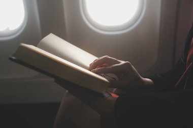 Sarışın kadın turist gelen bildirim netbook ile uçak koltuğunda oturan Smartphone cep telefonu ile kontrol. Genç işkadını paylaşmak medya telefonu dizüstü bilgisayar üzerinde uçak uçuş sırasında