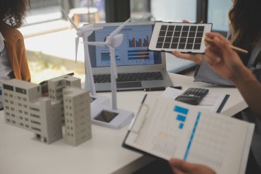 Elektrik mühendisi ve iş adamı binanın çatısındaki yeni güneş pili panelini tartışıyorlar. Alternatif enerji kavramı.