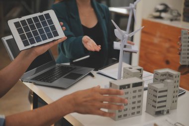 Elektrik mühendisi ve iş adamı binanın çatısındaki yeni güneş pili panelini tartışıyorlar. Alternatif enerji kavramı.
