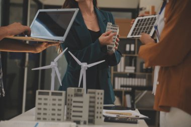 Elektrik mühendisi ve iş adamı binanın çatısındaki yeni güneş pili panelini tartışıyorlar. Alternatif enerji kavramı.