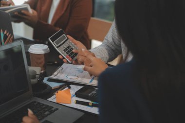 İş ekibi toplantısı yeni bir başlangıç projesi üzerinde çalışıyor, verileri tartışıyor ve analiz ediyor çizelgeler ve grafikler. Dijital tablet, hesap makinesi, dizüstü bilgisayar kullanımı, iş finans ve muhasebe kavramı.