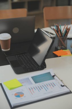 İş ekibi toplantısı yeni bir başlangıç projesi üzerinde çalışıyor, verileri tartışıyor ve analiz ediyor çizelgeler ve grafikler. Dijital tablet, hesap makinesi, dizüstü bilgisayar kullanımı, iş finans ve muhasebe kavramı.