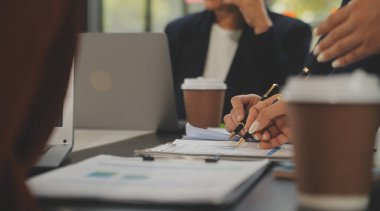 İş ekibi toplantısı yeni bir başlangıç projesi üzerinde çalışıyor, verileri tartışıyor ve analiz ediyor çizelgeler ve grafikler. Dijital tablet, hesap makinesi, dizüstü bilgisayar kullanımı, iş finans ve muhasebe kavramı.